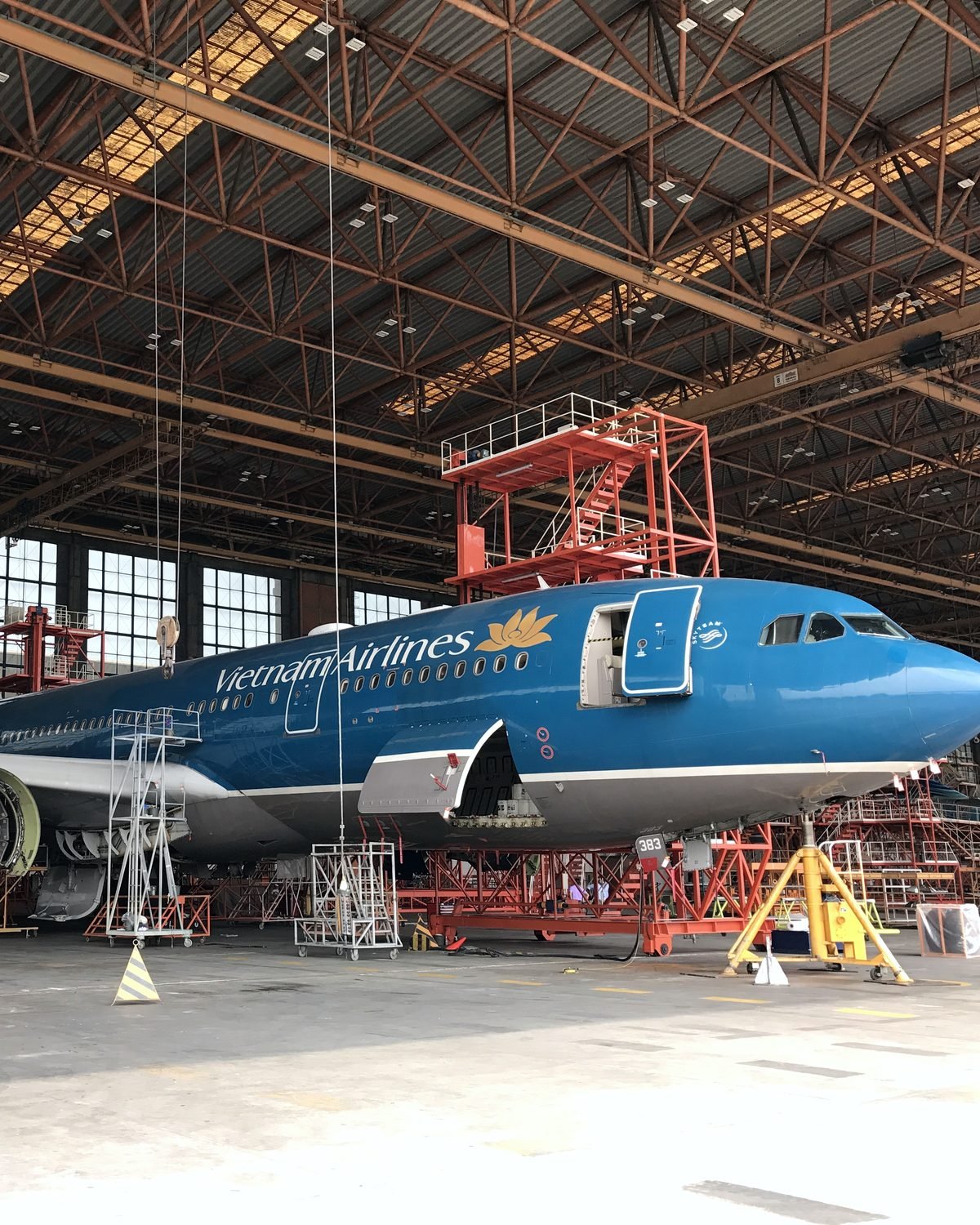 越南航空宽体客机在机库进行大修，机头周围搭设维修平台